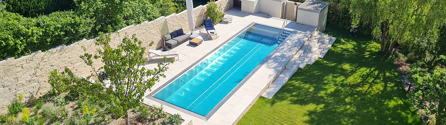 Edelstahlpool mit Gegenstromanlage und großer Liegefläche in stilvoll angelegtem Garten