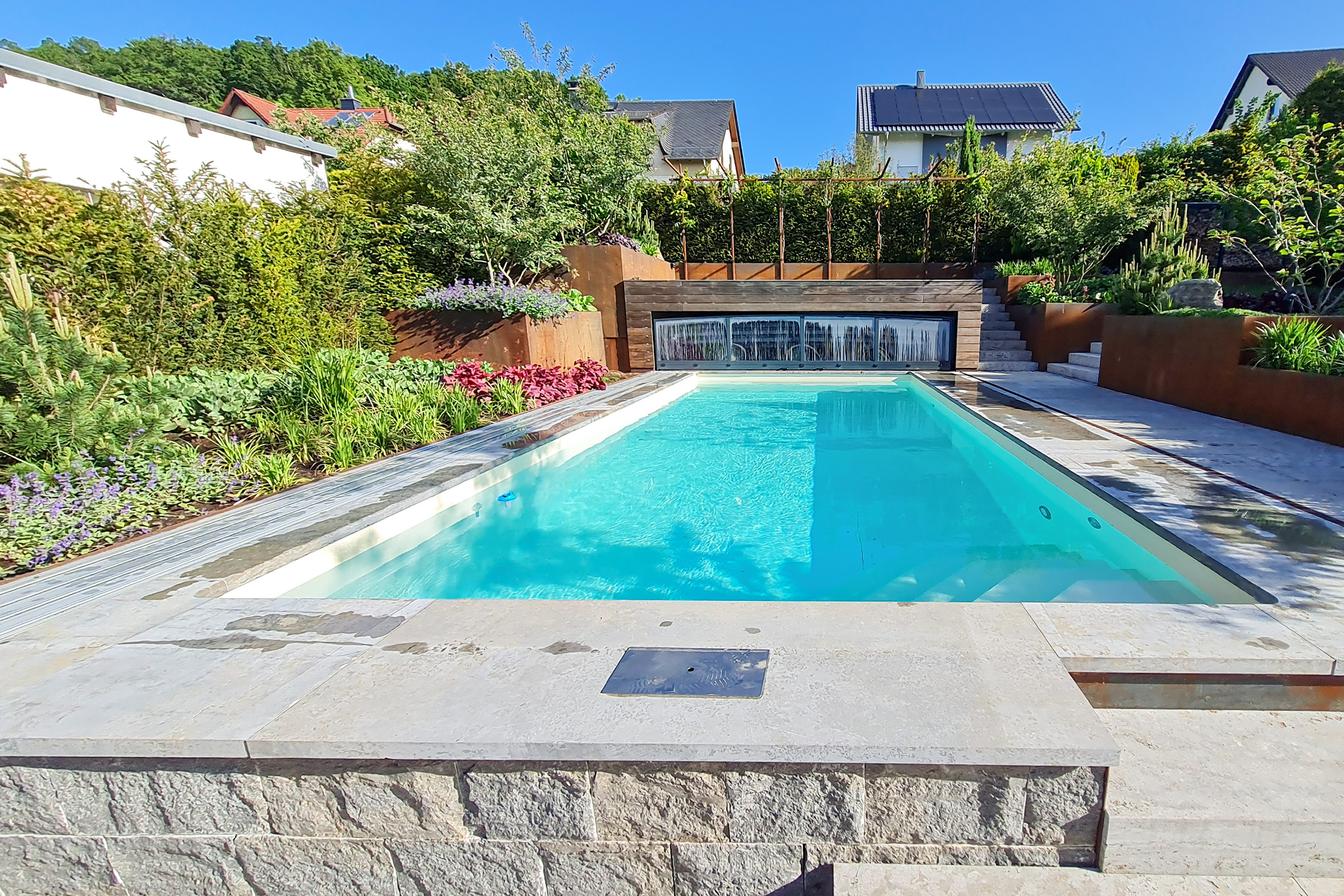 Geöffnete Poolüberdachung mit klarem Blick auf das Becken in moderner Gartenumgebung