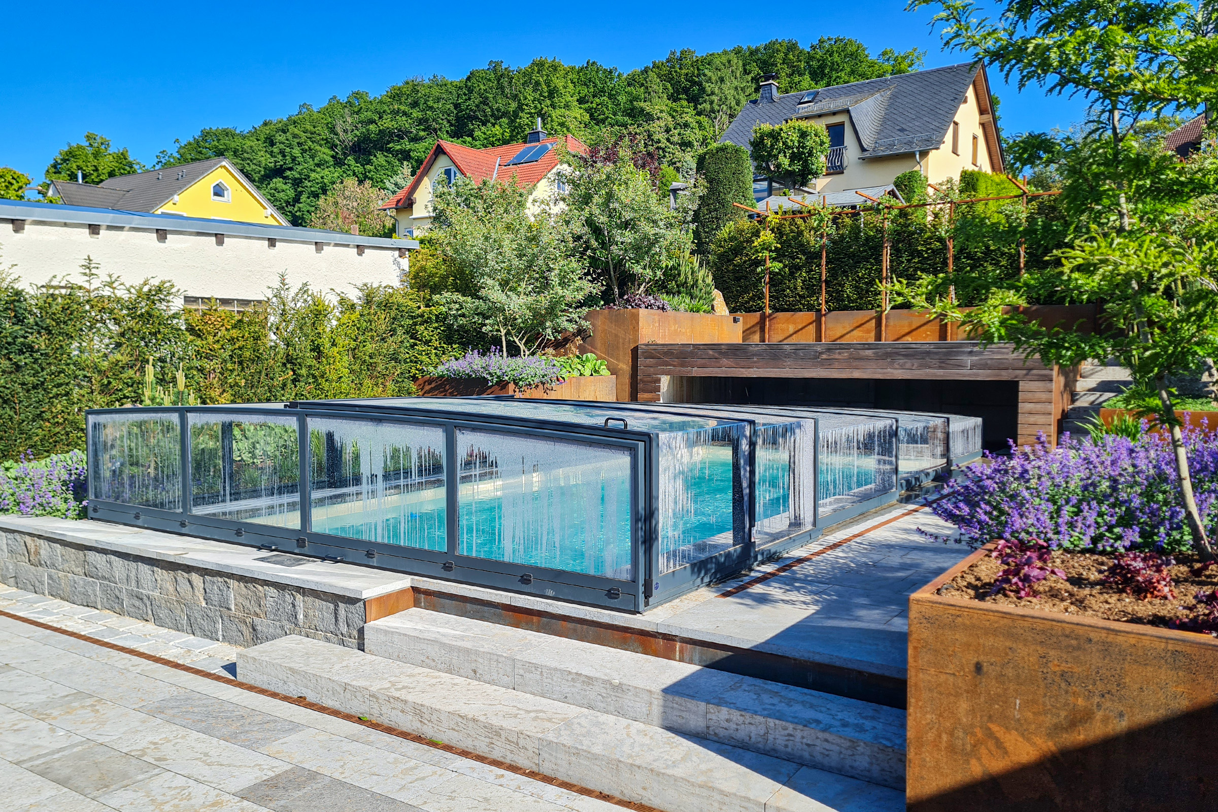 Pool mit Natursteinrand und farbenfrohem Garten