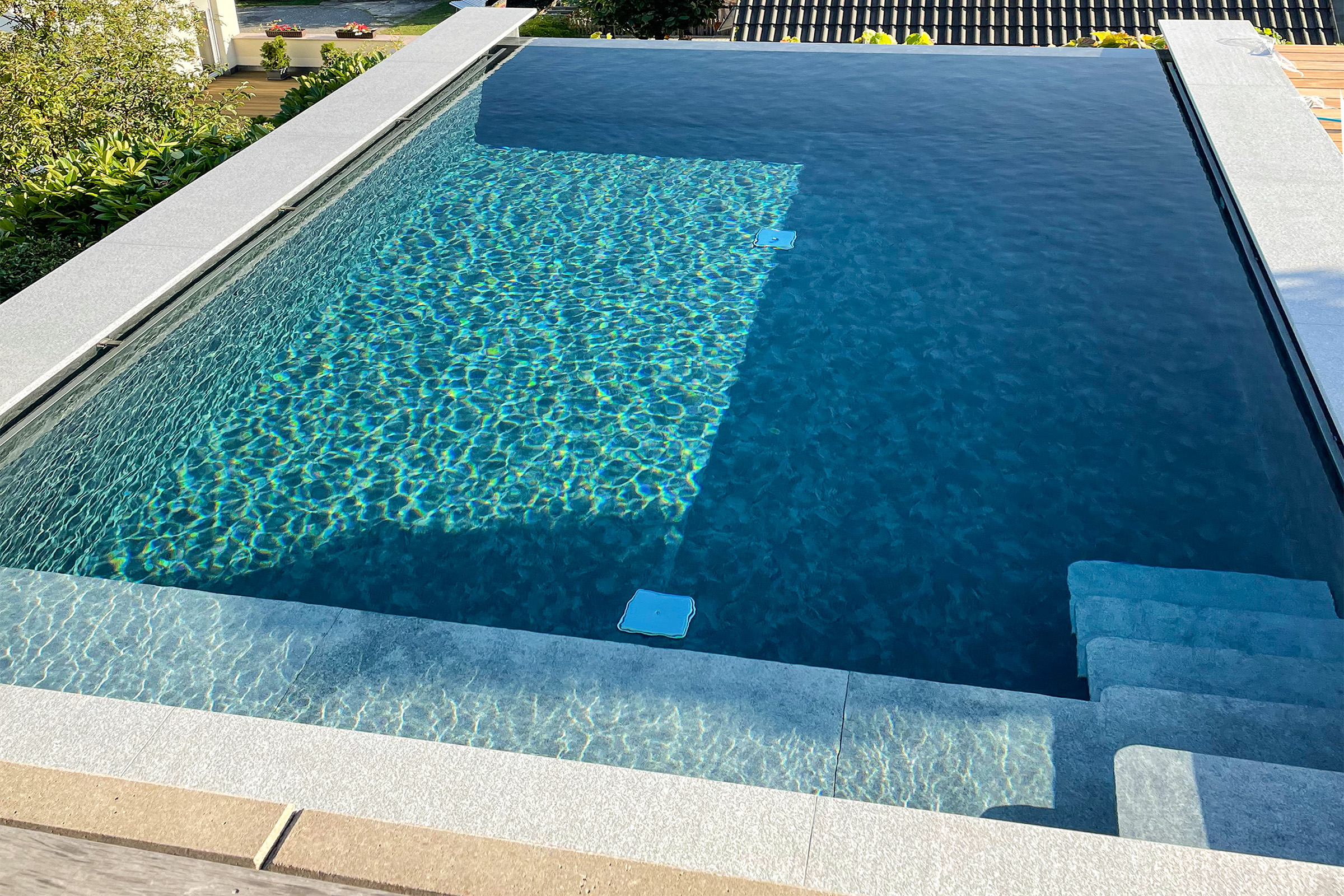 betonbecken-mit-infinityrinne-und-freitragender-treppe-aus-granit
