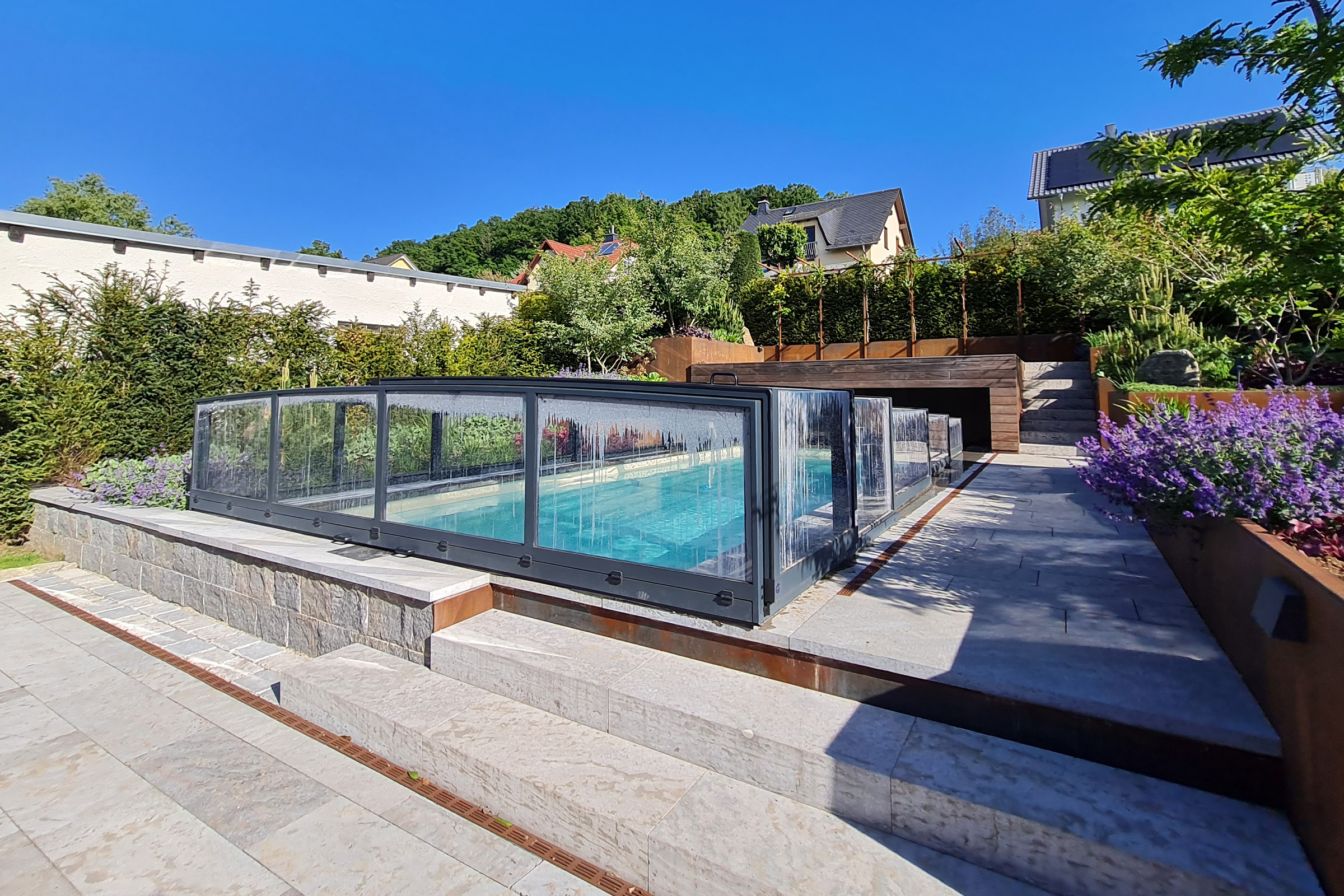 Flache Poolüberdachung mit transparenter Verglasung und anthrazitfarbenem Rahmen